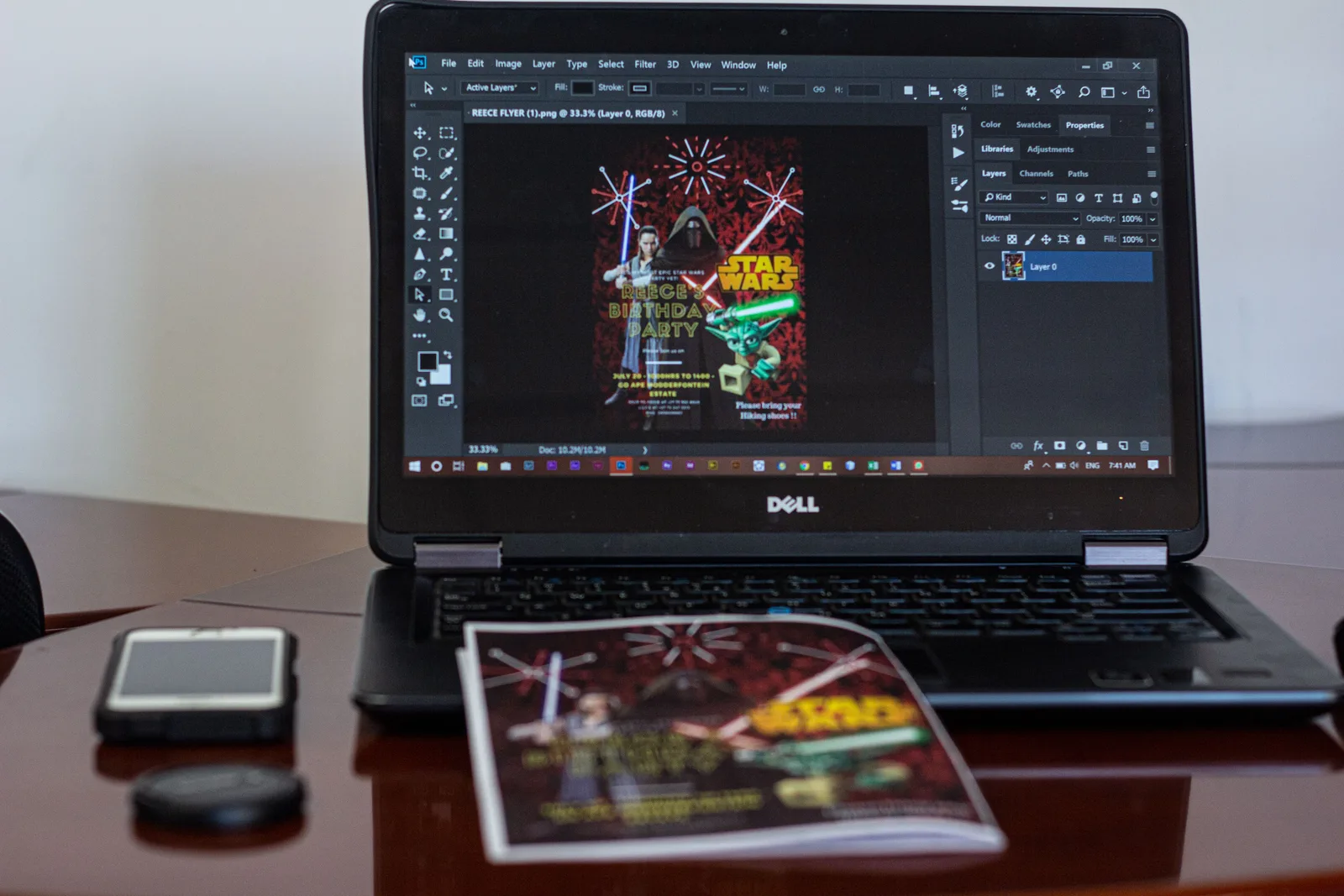 A laptop displaying Star Wars party invitation design in a workspace setting. Marketing collateral tools compared on rights, proofs and exports
