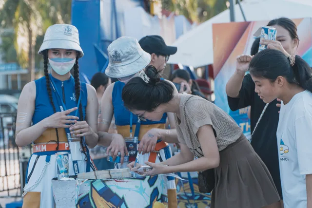 People interacting at an outdoor festival booth wearing colorful outfits and hats. 3 things about trade show marketing best practices worth your time