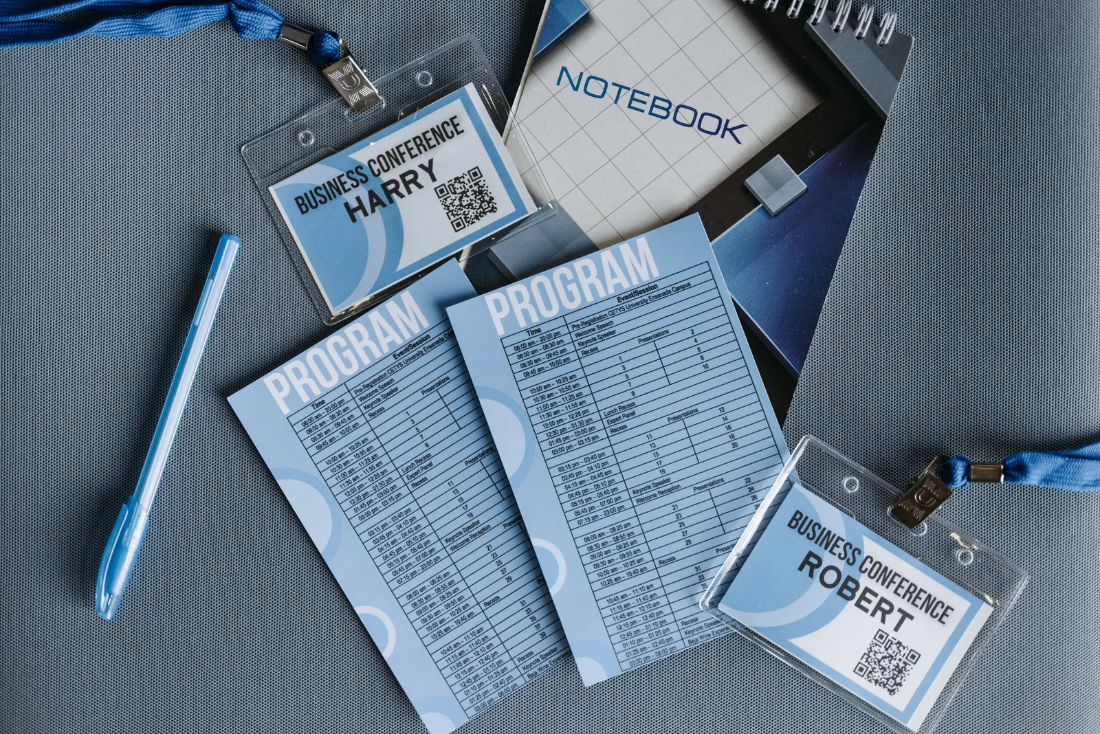 Flat lay of business conference materials including name tags, program, notebook, and pen. Trade show lead capture: six tests to run before the show
