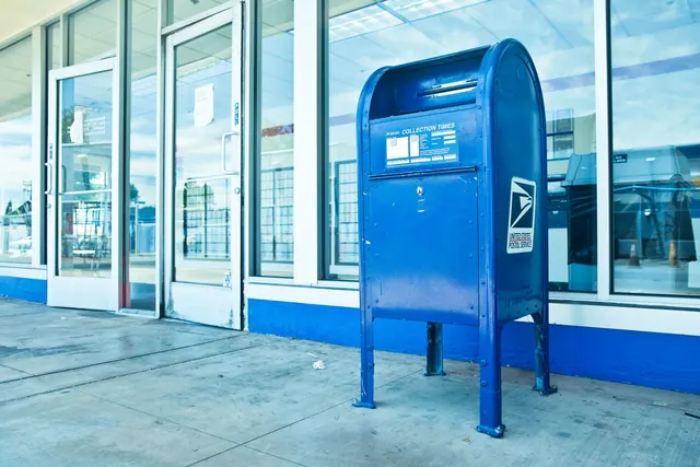 USPS blue mailbox against a post office facade in Los Angeles, CA. A practical guide to USPS Every Door Direct Mail rates