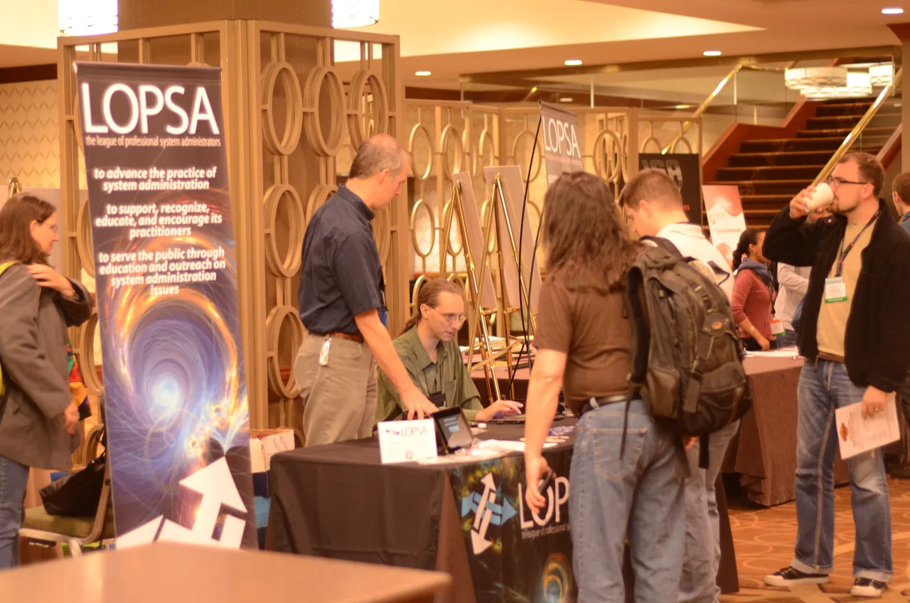 Conference attendees speak with representatives at an information booth.
